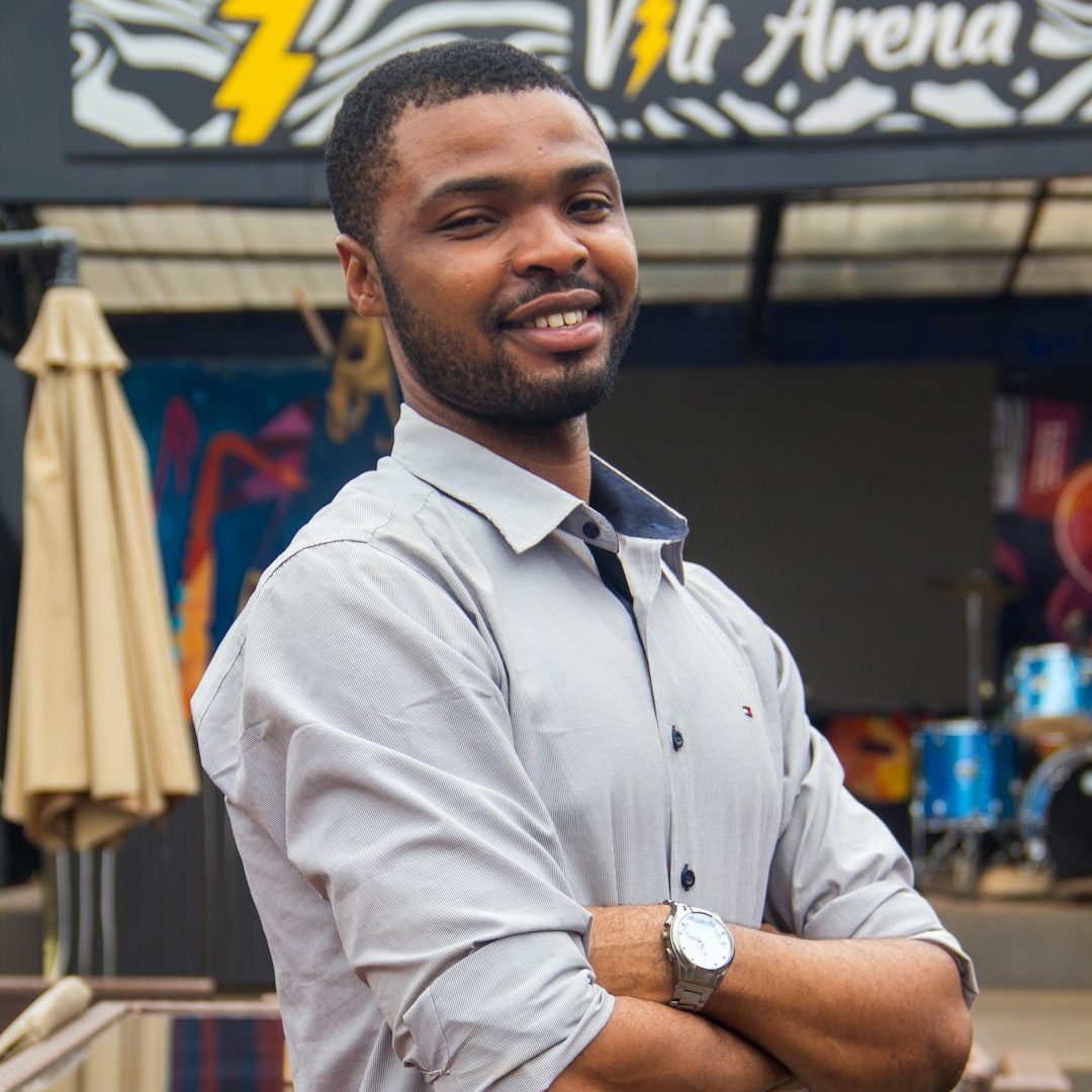 A man standing in front of a store with his arms crossed